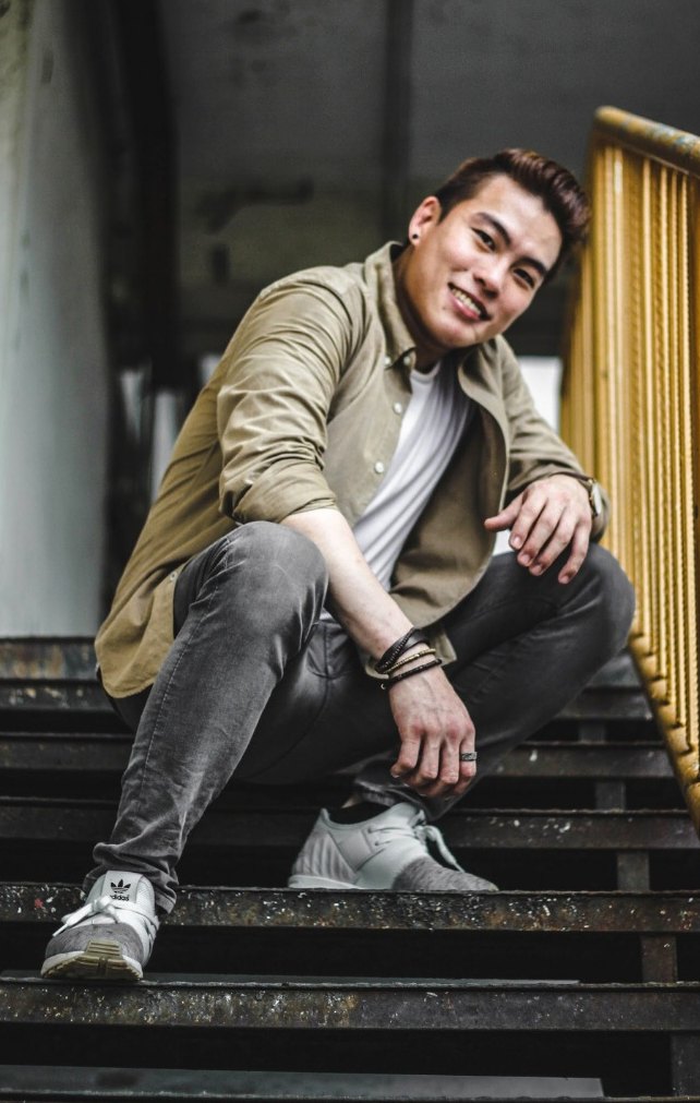 Wen Jun crouching on a staircase, smiling