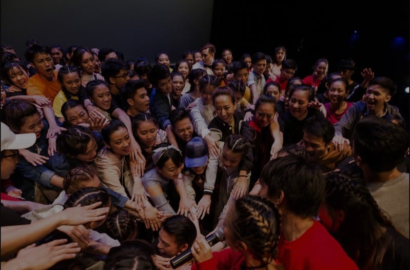 A large group of STEP dancers huddled together smiling