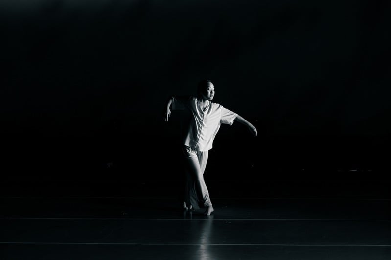 Director Step performing solo under a single spotlight